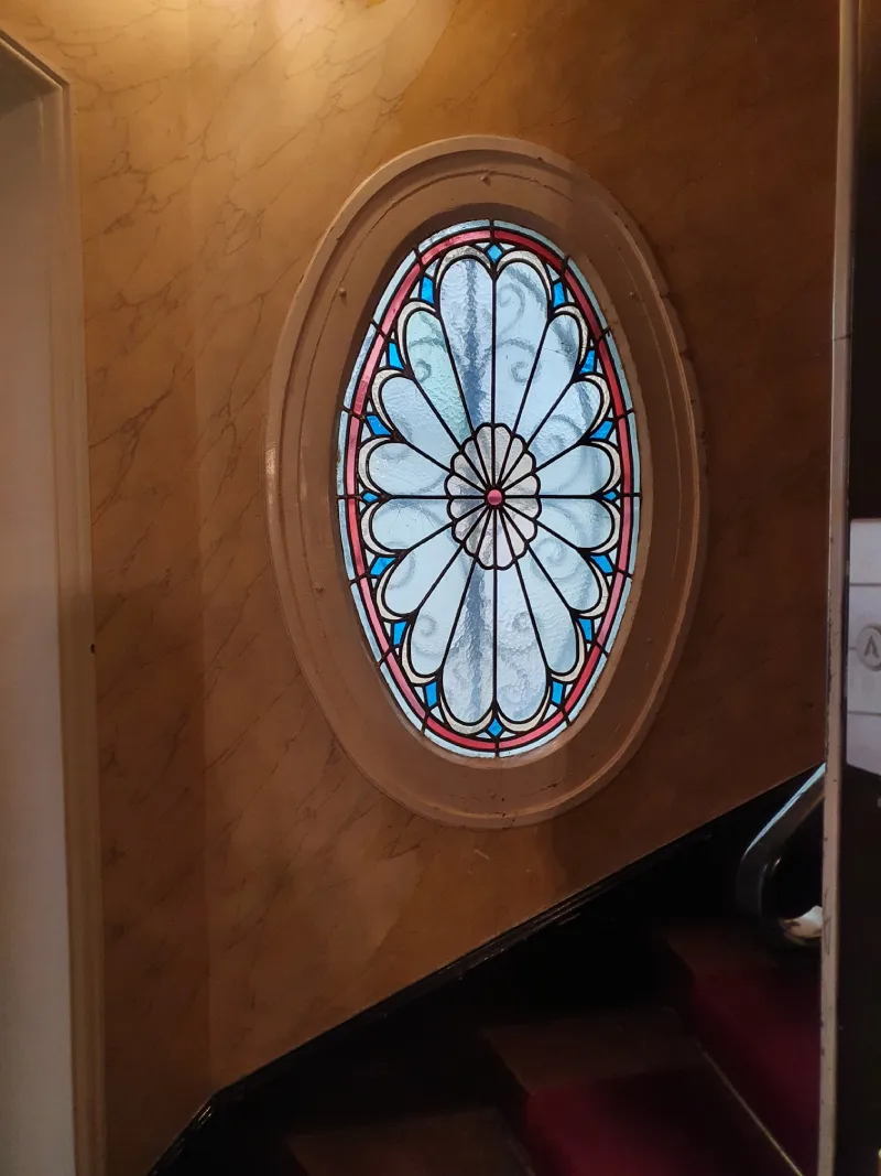 Vitrail en forme de rond sur un mur dans des escaliers